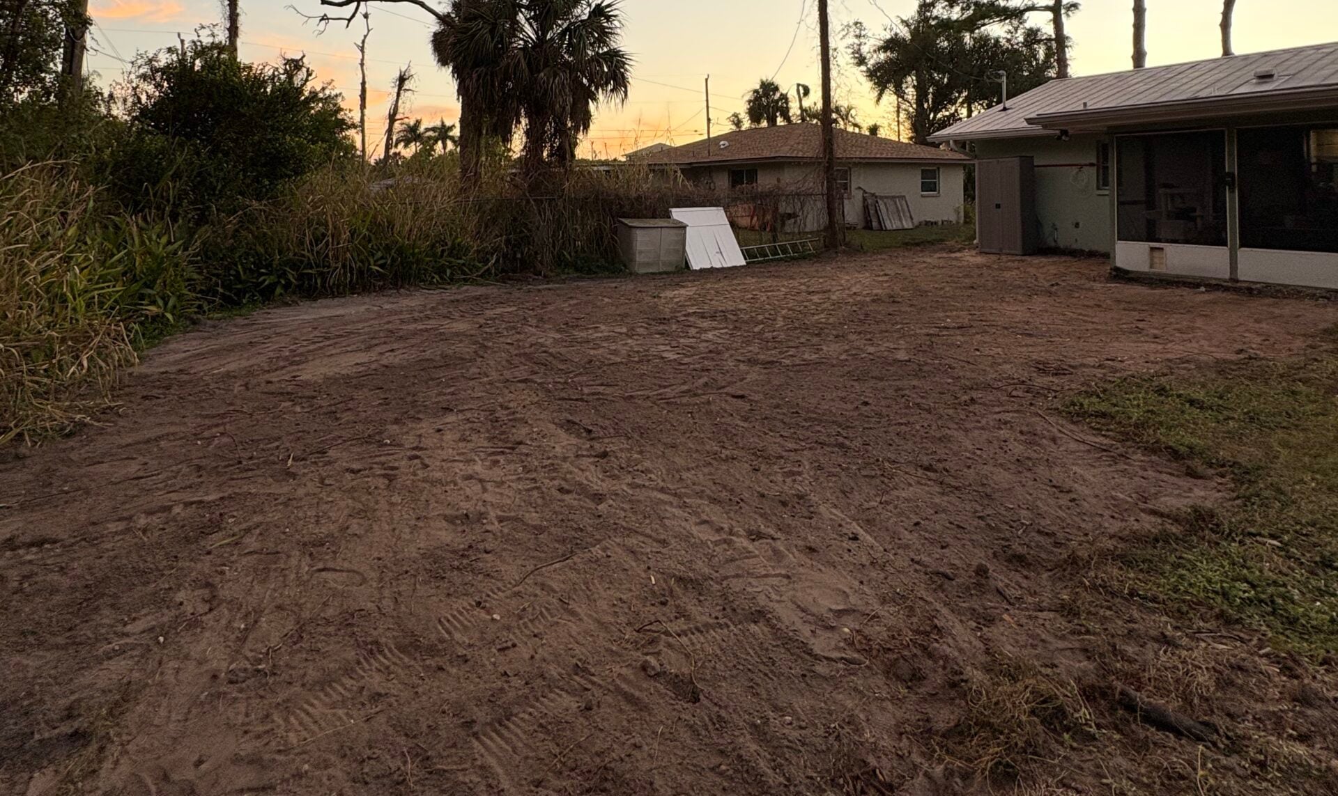 Cleared and graded residential backyard at sunset, ready for the next phase, in Southwest Florida