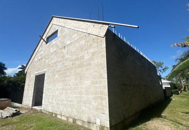 New concrete block building under construction with tie beam and rebar on a poured foundation in Southwest Florida