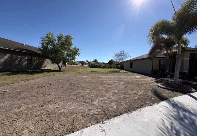 Graded side yard between two homes leveled and prepped for sod in Cape Coral, FL