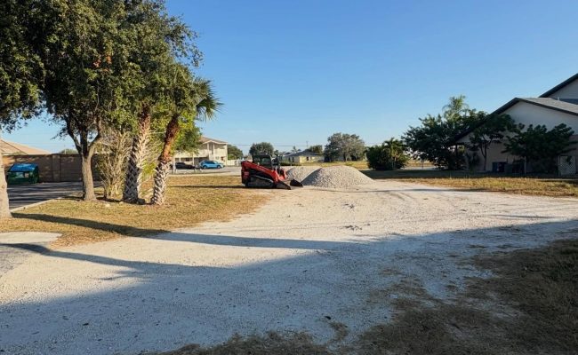 Takeuchi track loader spreading crushed shell to surface a wide driveway on a corner lot in Cape Coral, FL